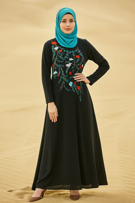 Woman wearing a black dress with floral embroidery and a turquoise hijab on a beige background