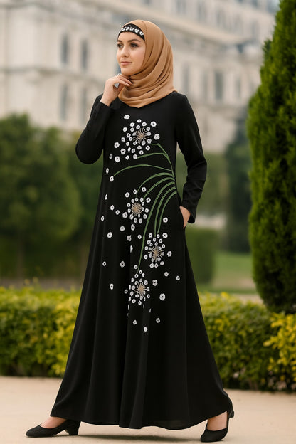 Woman wearing a black dress with floral embroidery in an outdoor setting