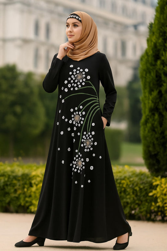 Woman wearing a black dress with floral embroidery in an outdoor setting