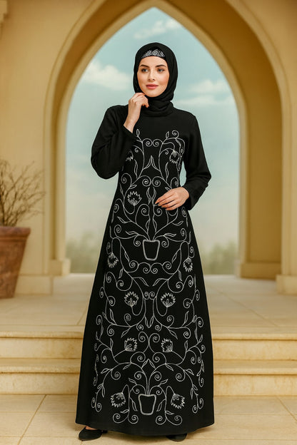 Woman wearing a black abaya with white embroidery in front of an archway.