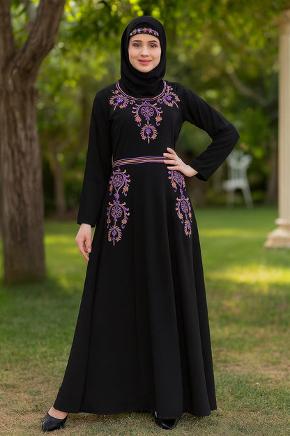 Woman wearing a black dress with purple embroidery standing outdoors.