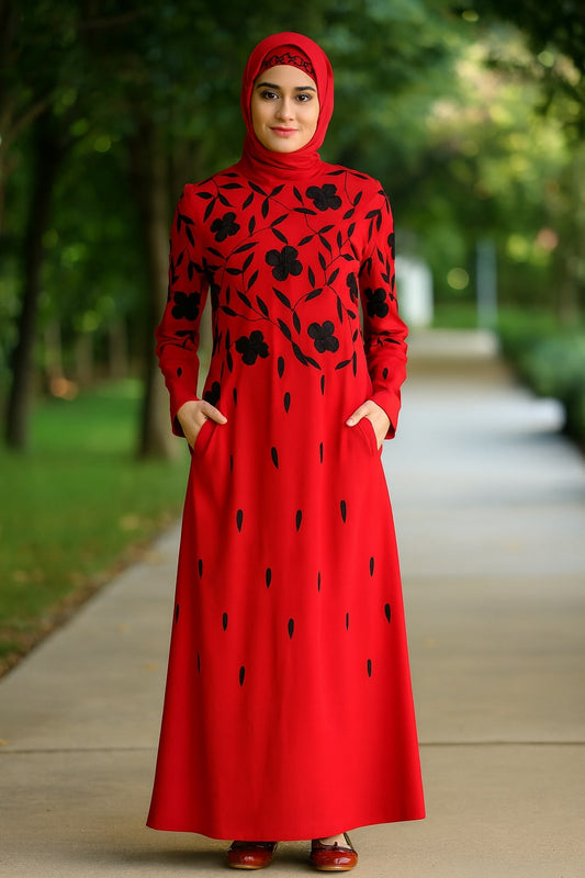 Woman wearing a red dress with black floral patterns in an outdoor setting