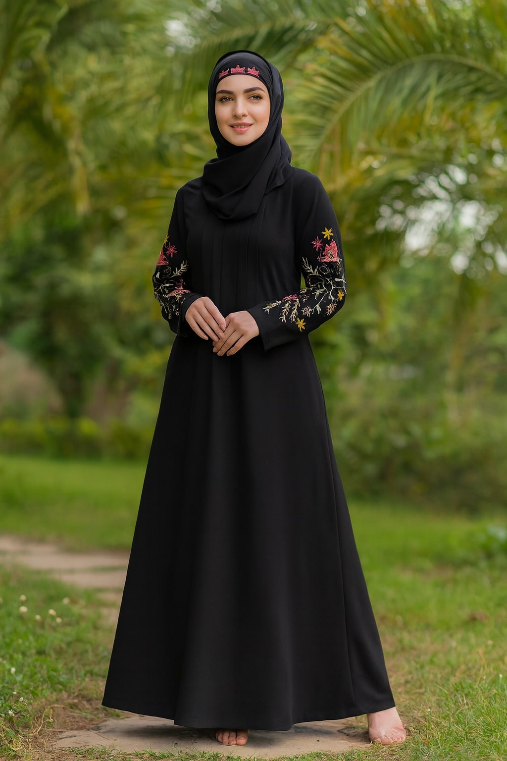 Woman wearing a black abaya with floral embroidery in a garden setting