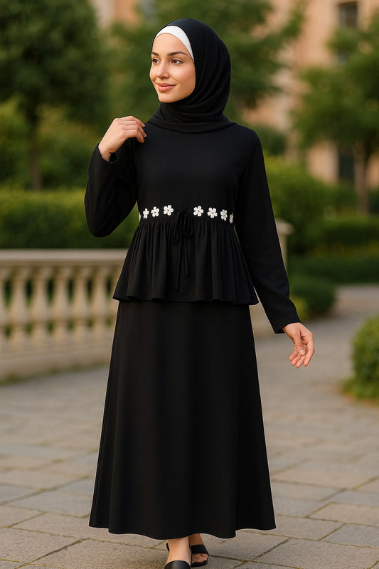 Woman wearing a black dress with floral details outdoors