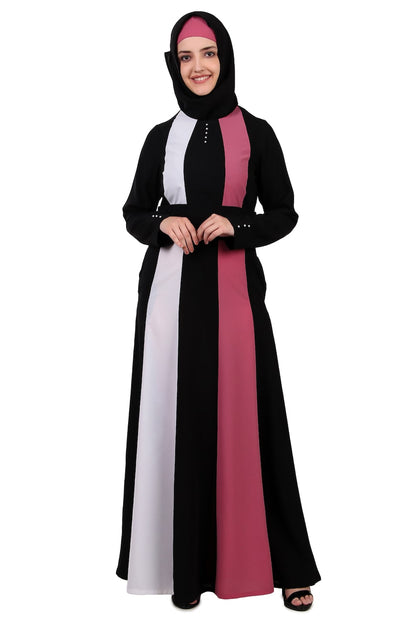 A woman wearing a multi-colored abaya with black, white, and pink panels, featuring a round neckline and sleeve details.