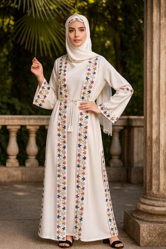 Woman wearing a white dress with colorful floral patterns in an outdoor setting.