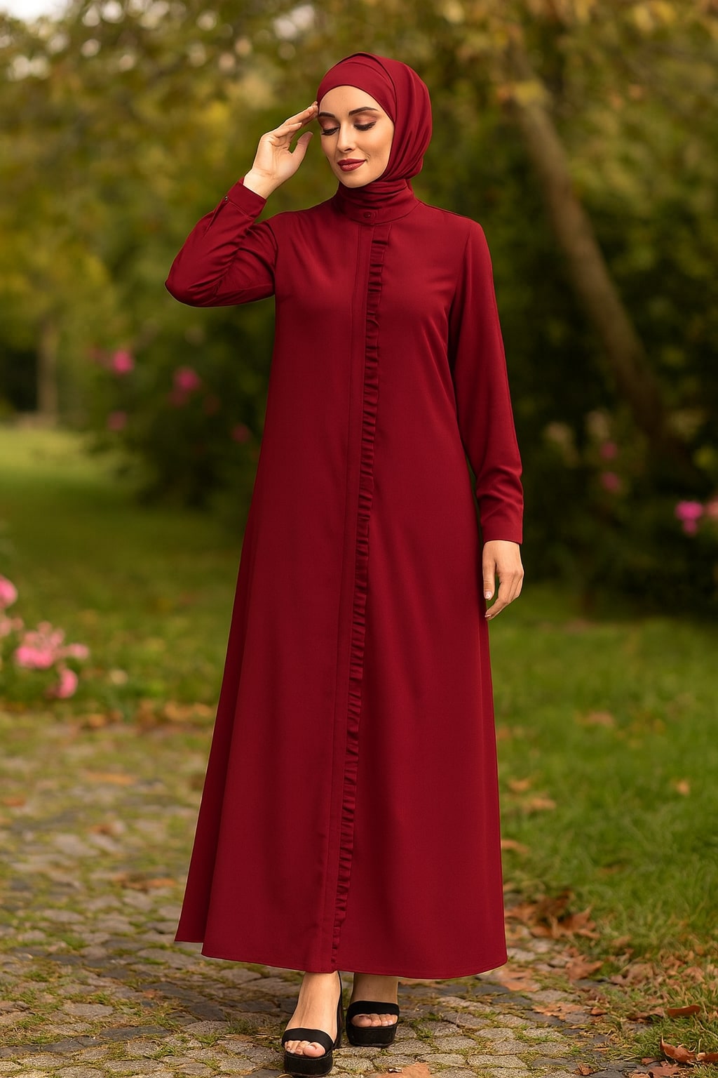 Woman wearing a burgundy dress with a hijab in a park setting