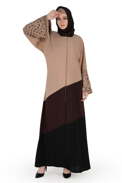 A model wearing a Dubai abaya with mirror work embroidery in warm grey, brown, and black colors. The abaya has a round neckline, straight sleeves with embroidery, and is paired with a matching headscarf.