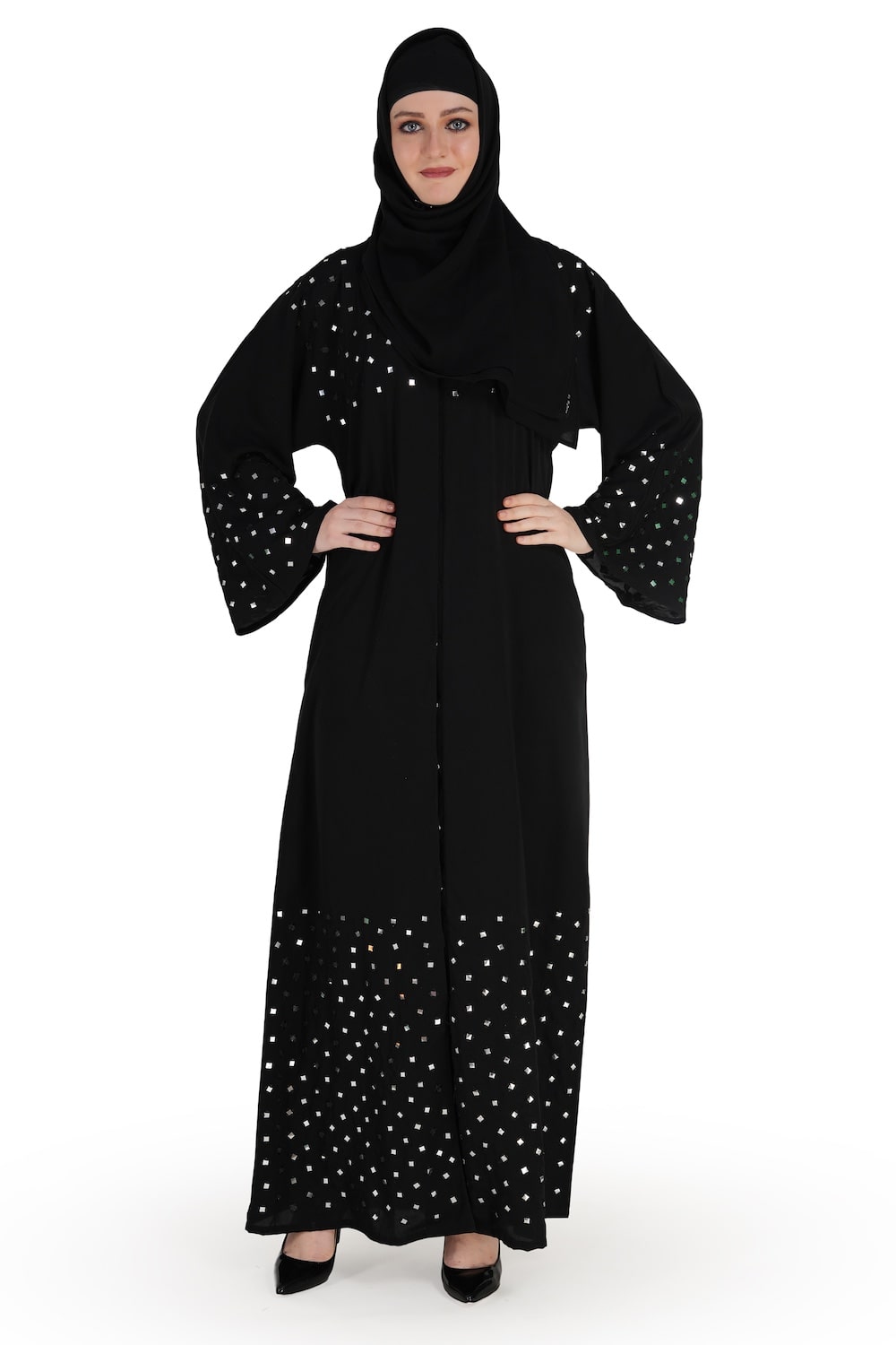A model wearing a black abaya with mirror work embroidery, with a round neckline and straight sleeves. The abaya is fully visible, showing the front and side, with no visible face to protect the model's identity.