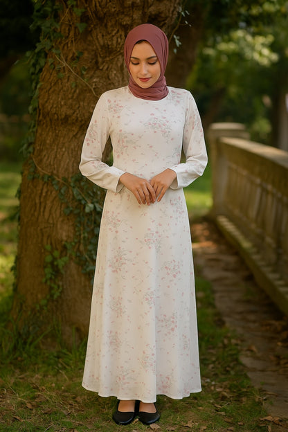 Woman in a white lace dress and hijab standing outdoors near a tree