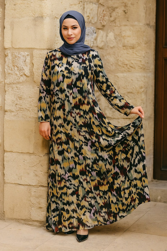 Woman wearing a long, patterned dress against a stone wall.