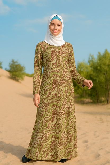 Woman wearing a long, patterned dress and hijab standing in a desert landscape.
