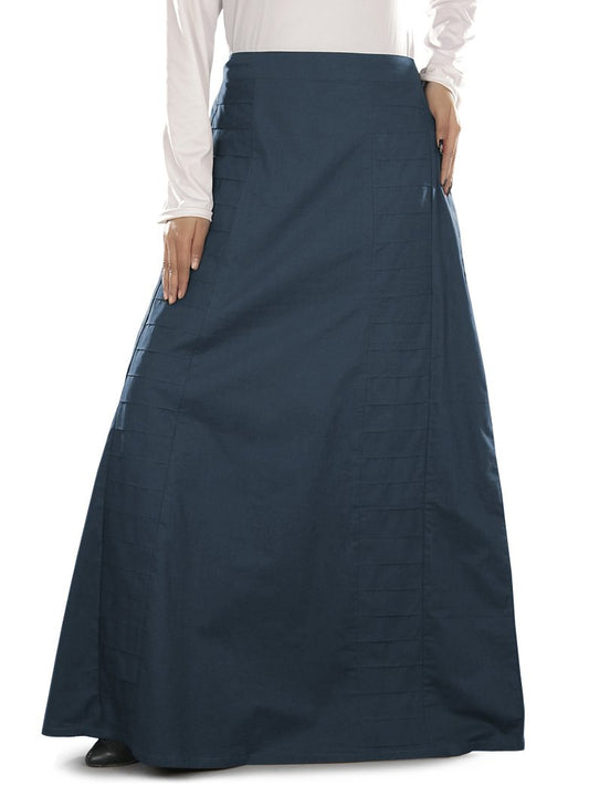 A navy blue pleated cotton skirt with elastic waist back and utility pockets on the sides, worn by a person standing against a white background.
