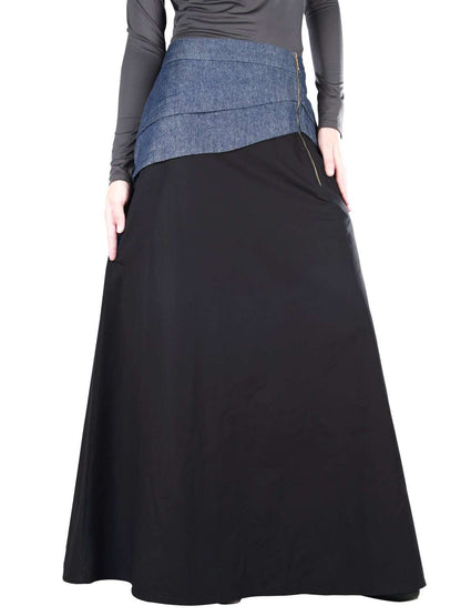 A black cotton denim skirt with a side zipper closure, asymmetric pleated denim patch on top, and utility pockets on the sides.
