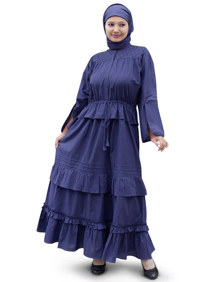 A woman wearing a blue Abal Abaya with layered frills and a square hijab.