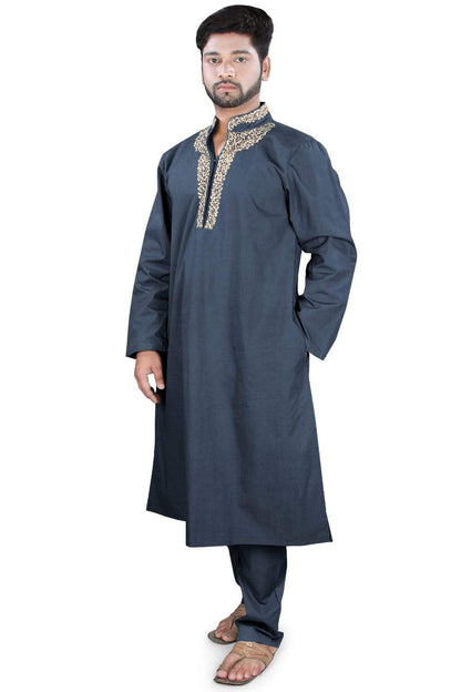 A man wearing a navy blue Kurta Pajama with embroidered details on the collar and front pocket pockets.